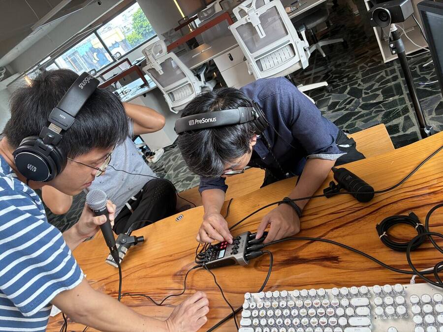 戴著耳機、對著麥克風錄 Podcast 的現場